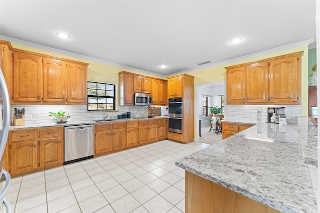 kitchen featuring visible vents, light tile patterned floors, brown cabinets, stainless steel appliances, and a sink