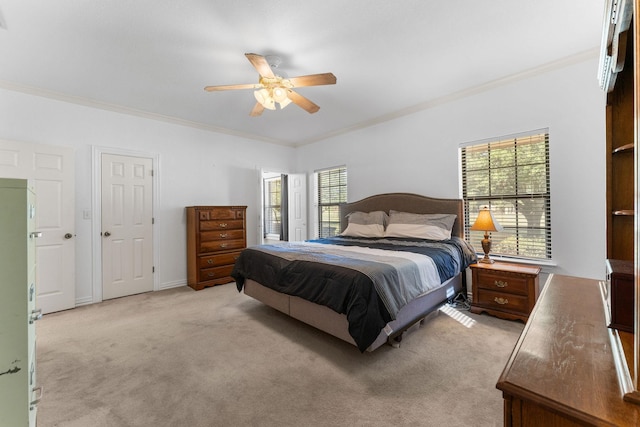 carpeted bedroom featuring ceiling fan and ornamental molding