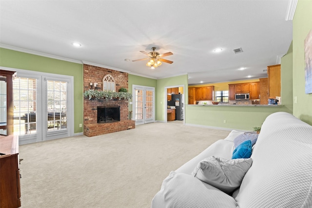 living room featuring recessed lighting, ceiling fan, crown molding, a brick fireplace, and light colored carpet