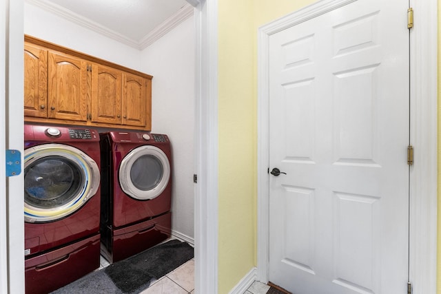 laundry room featuring baseboards, cabinet space, ornamental molding, washer and dryer, and tile patterned floors