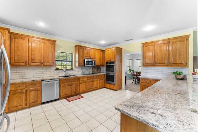 kitchen featuring light stone countertops, stainless steel appliances, ornamental molding, and sink