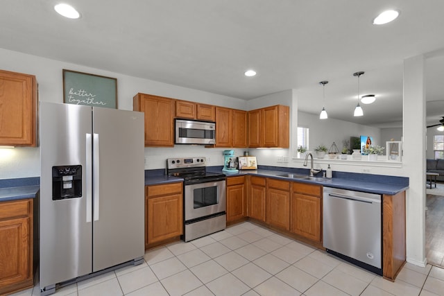 kitchen featuring stainless steel appliances, ceiling fan, sink, light tile patterned floors, and decorative light fixtures