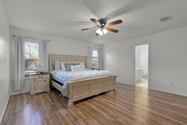 bedroom with dark hardwood / wood-style floors, ceiling fan, and connected bathroom