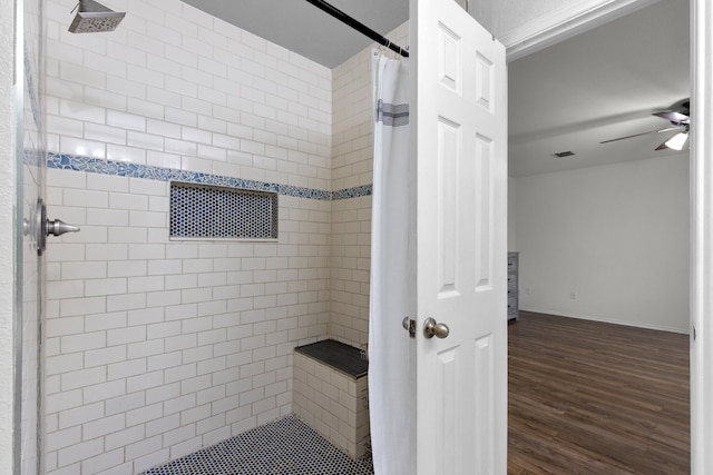 bathroom with hardwood / wood-style flooring, a shower with curtain, and ceiling fan