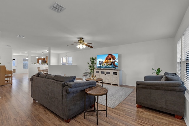 living room featuring hardwood / wood-style floors and ceiling fan