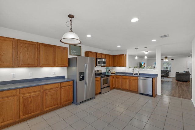 kitchen with appliances with stainless steel finishes, light hardwood / wood-style flooring, hanging light fixtures, and ceiling fan