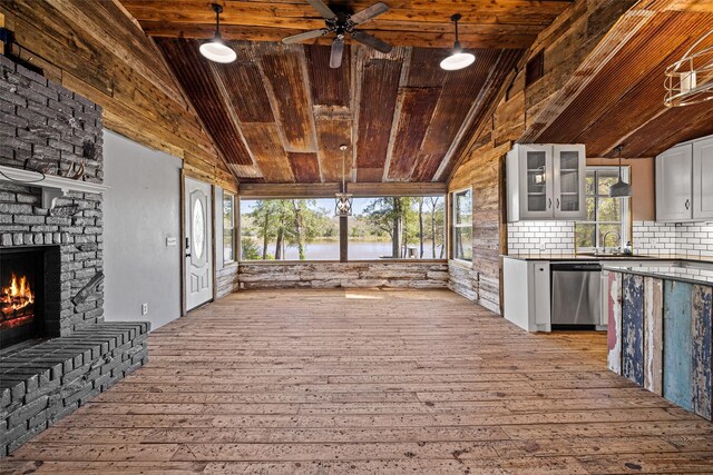 interior space featuring ceiling fan, a large fireplace, a water view, and sink