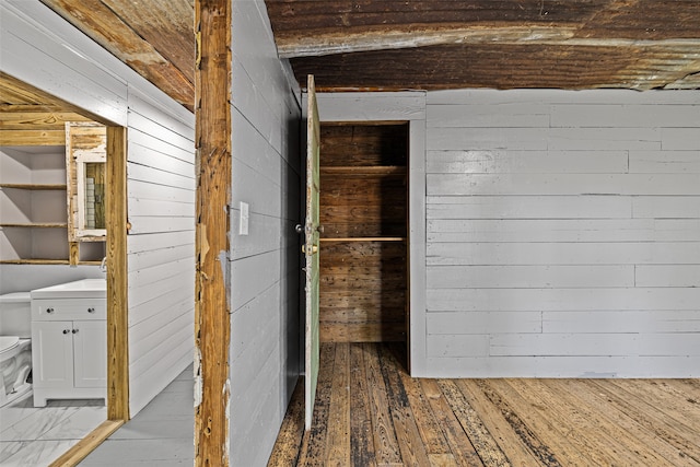 interior space with light hardwood / wood-style flooring and wooden walls