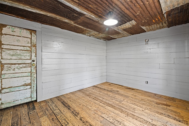 basement featuring wooden walls, hardwood / wood-style flooring, and wooden ceiling