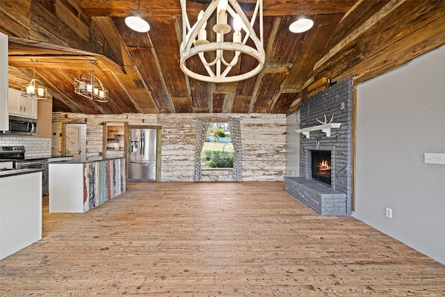 unfurnished living room featuring vaulted ceiling with beams, light wood-type flooring, a fireplace, and wood ceiling