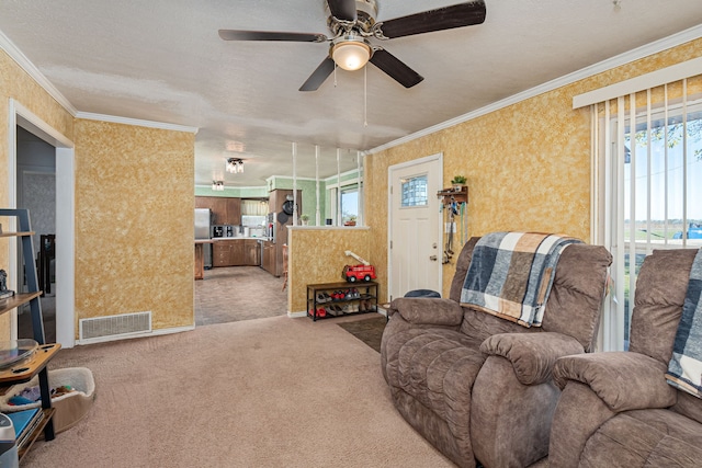 living room with a textured ceiling, carpet floors, ceiling fan, and crown molding