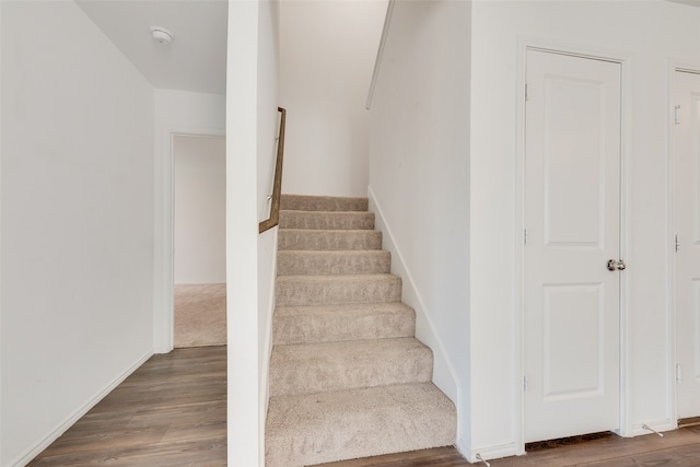 stairs featuring hardwood / wood-style floors