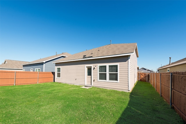 rear view of property featuring a lawn