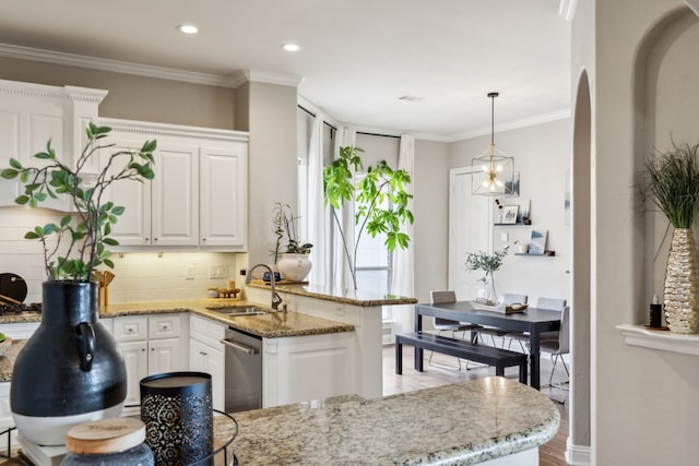 kitchen featuring sink, light hardwood / wood-style flooring, light stone countertops, decorative light fixtures, and white cabinetry