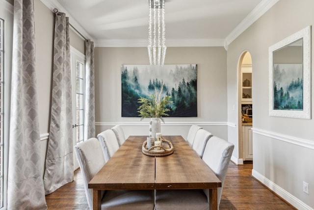 dining space featuring a notable chandelier, dark hardwood / wood-style flooring, and ornamental molding