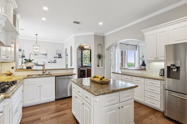 kitchen featuring white cabinetry, stainless steel appliances, dark hardwood / wood-style floors, kitchen peninsula, and a kitchen island