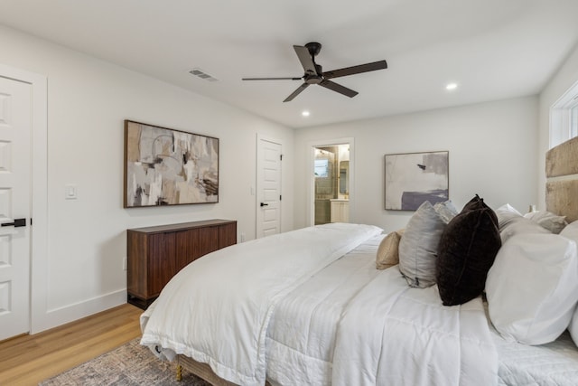 bedroom with ensuite bathroom, light hardwood / wood-style flooring, and ceiling fan