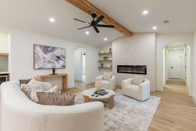 living room featuring vaulted ceiling with beams, ceiling fan, built in features, and light hardwood / wood-style floors