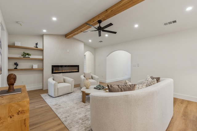 living room with vaulted ceiling with beams, ceiling fan, and light hardwood / wood-style floors