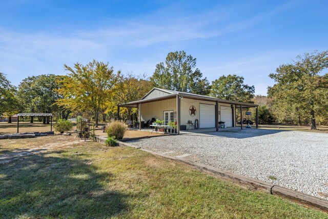 exterior space with a lawn, a garage, and an outdoor structure