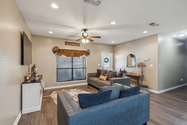 living room featuring ceiling fan and dark wood-type flooring