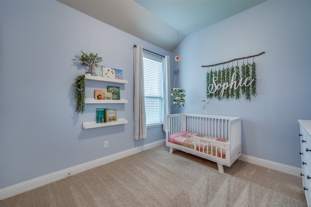 carpeted bedroom featuring a nursery area and vaulted ceiling