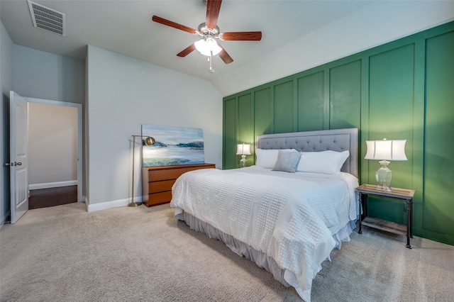 bedroom with ceiling fan, light colored carpet, and vaulted ceiling