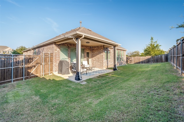 back of property with a lawn and a patio area