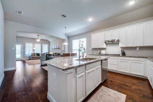 kitchen featuring white cabinetry, an island with sink, sink, hanging light fixtures, and light stone counters