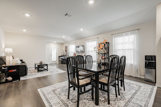 dining area featuring dark hardwood / wood-style floors and vaulted ceiling