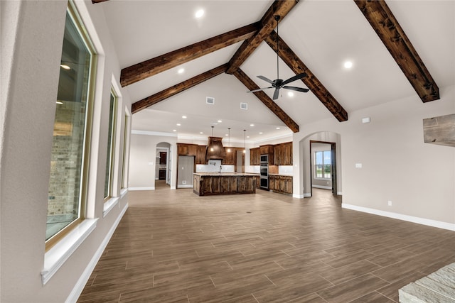 unfurnished living room featuring beamed ceiling, ceiling fan, dark wood-type flooring, and high vaulted ceiling