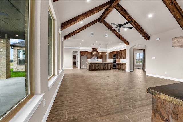 living room featuring beamed ceiling, dark hardwood / wood-style flooring, and plenty of natural light