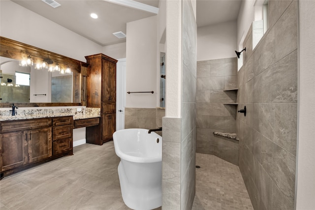 bathroom featuring vanity, tile walls, and shower with separate bathtub