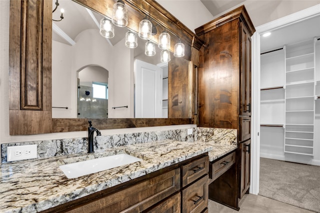 bathroom featuring vanity, vaulted ceiling, and walk in shower