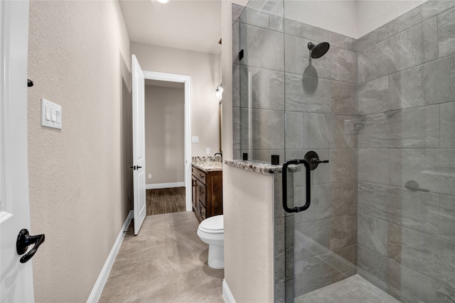 bathroom featuring vanity, toilet, and a shower with shower door