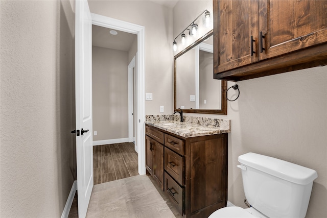 bathroom with vanity, hardwood / wood-style flooring, and toilet