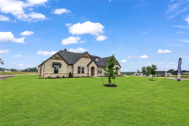 french country inspired facade with a front yard