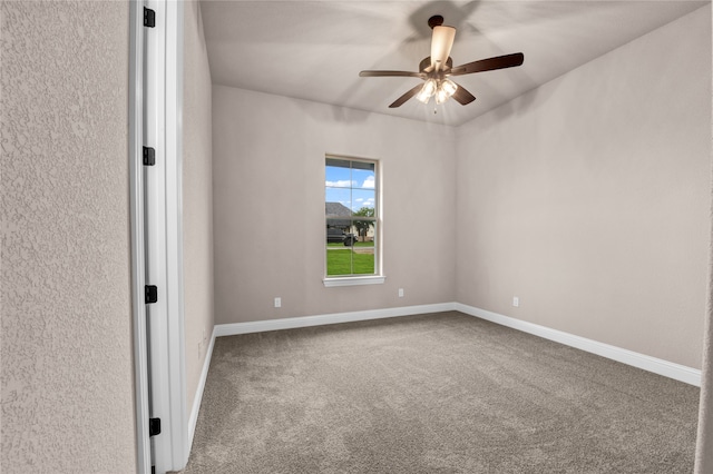 carpeted spare room featuring ceiling fan