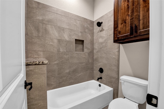 bathroom featuring tiled shower / bath combo and toilet