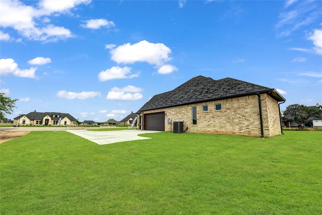 back of house with a yard, a garage, and central AC unit