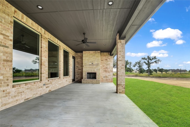 view of patio / terrace featuring an outdoor brick fireplace and ceiling fan