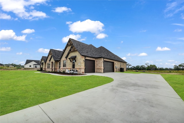 french country style house featuring a garage and a front lawn