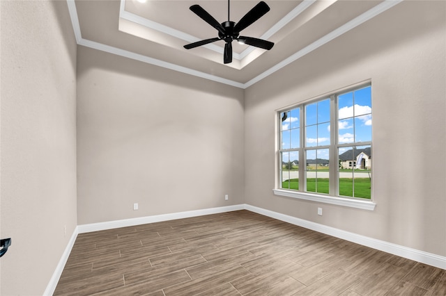 spare room with hardwood / wood-style floors, ceiling fan, a raised ceiling, and ornamental molding