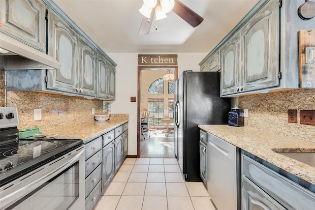 kitchen featuring tasteful backsplash, premium range hood, gray cabinetry, stainless steel appliances, and light tile patterned floors