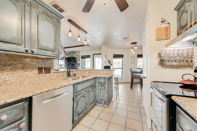 kitchen featuring pendant lighting, sink, appliances with stainless steel finishes, tasteful backsplash, and light tile patterned flooring