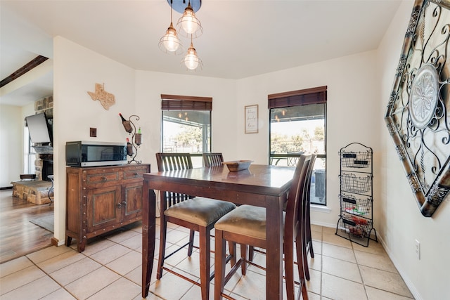 tiled dining space with a fireplace