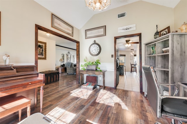 interior space with hardwood / wood-style floors, ceiling fan with notable chandelier, and vaulted ceiling