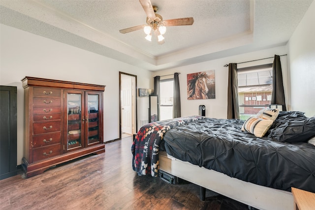 bedroom featuring ceiling fan, a raised ceiling, and multiple windows