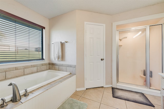 bathroom with tile patterned floors, separate shower and tub, and a textured ceiling