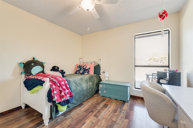 bedroom with ceiling fan, dark wood-type flooring, and a textured ceiling